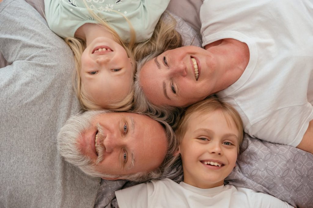 Home A joyful multigenerational family lying down and smiling together, displaying warmth and affection.